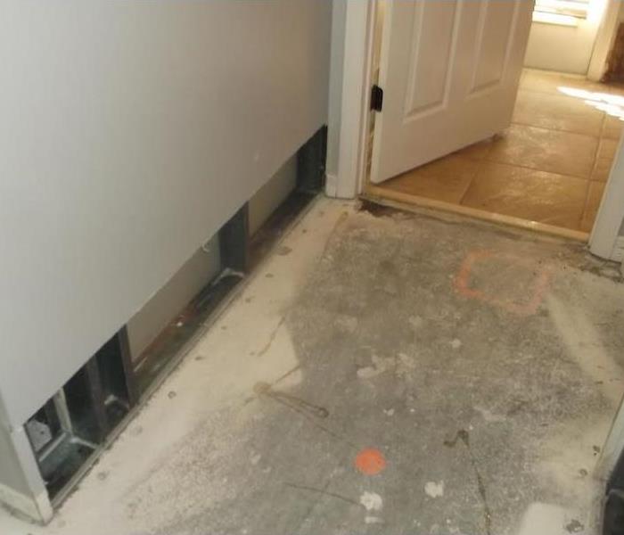 Hallway with controlled demo on sheetrock by tile floor