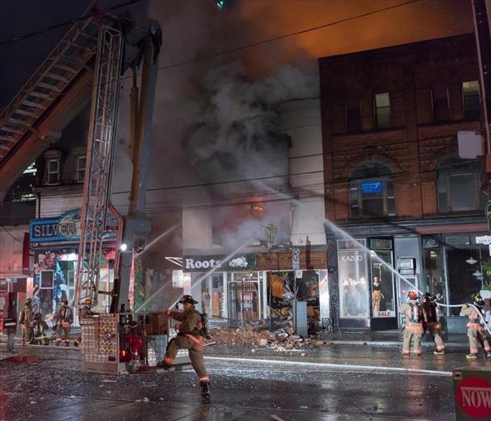 night time 4 store fronts with fire trucks and water hoses